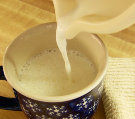 warm milk being poured into a mug 